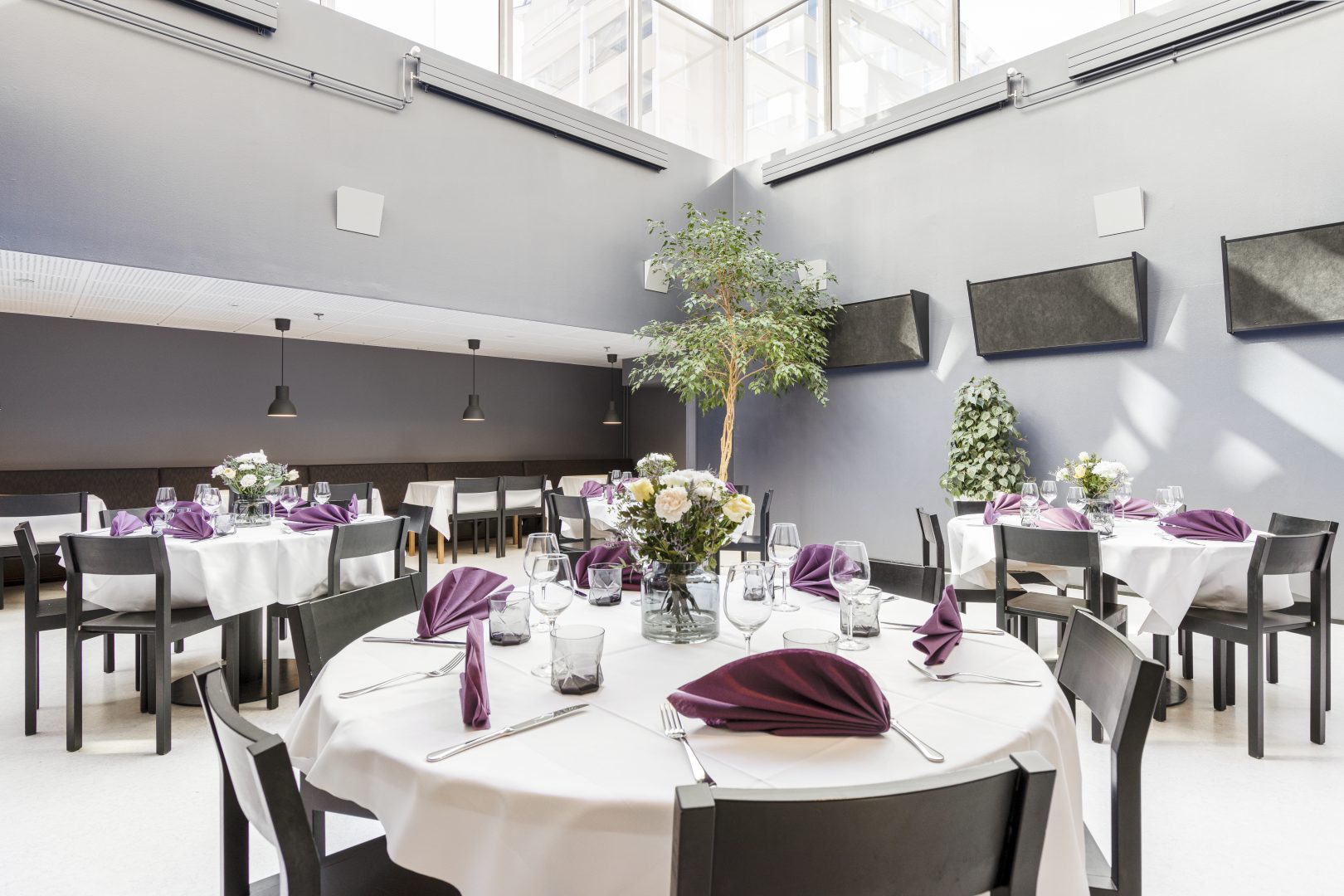 Domuksen ravintolasali on täynnä luonnonvaloa kattoikkunoiden ansiosta. Tilaan soveltuu erityisen hyvin pyöreät pöydät.